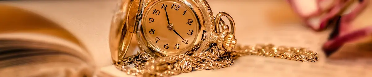 An antique pocket Closeup of an antique watch that is open and sitting on a dressing table.